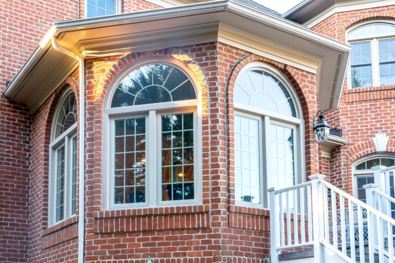 Beige exterior Vytex windows on a brick home