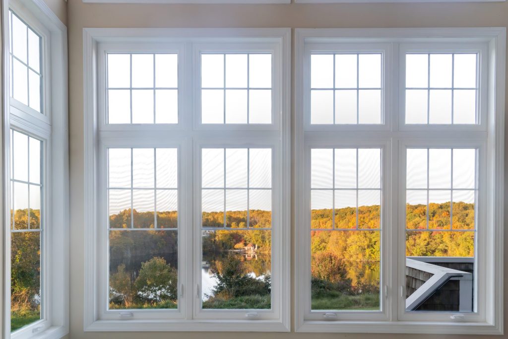 Bank of Vytex casement windows with colonial grids over a fall view