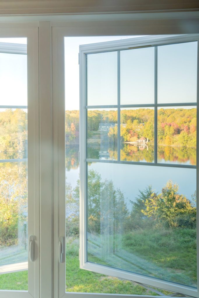 Vytex white casement window with grids and a fall view