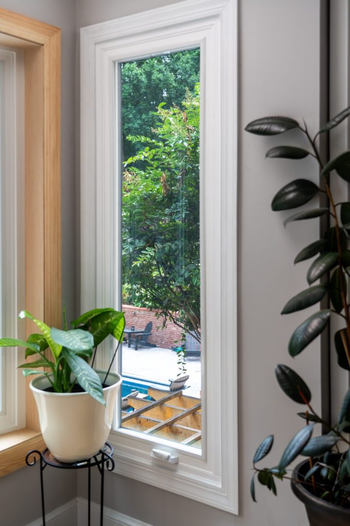 Vytex white casement window cranked open beside a houseplant