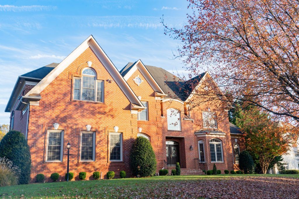 Vytex Fortis windows with beige exterior on a brick colonial home at golden hour