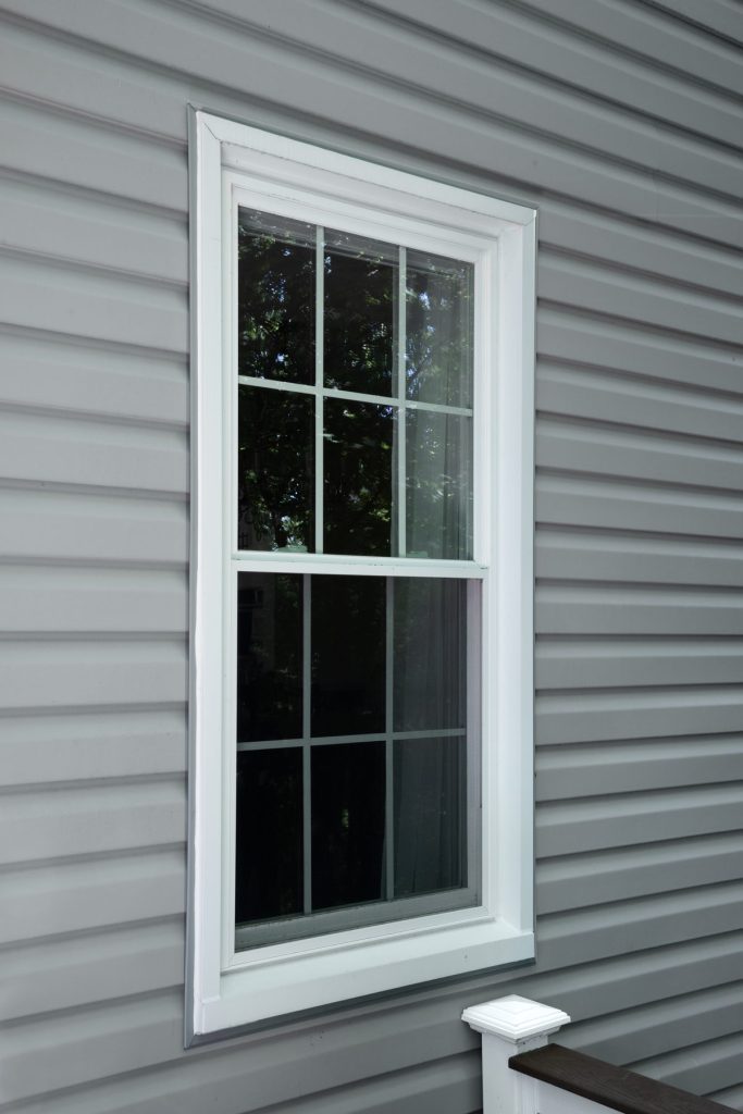 Vytex Fortis white double-hung window on gray siding