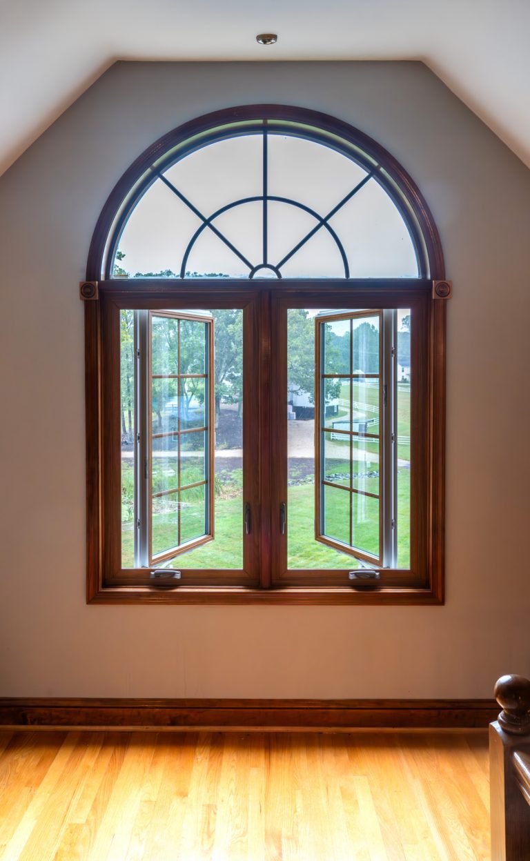 Vytex Potomac windows with VyWood woodgrain interior and an arched window