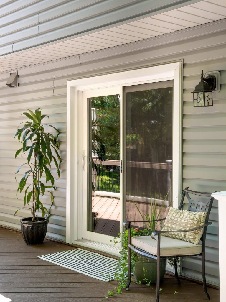 Vytex Signature Series white patio door on a deck with seating and plants