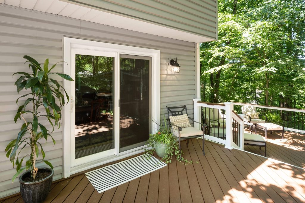Vytex Signature Series white patio door opening to a deck with wooded view