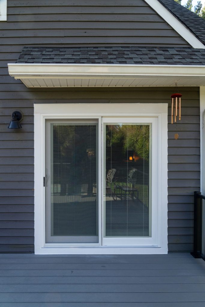 Vytex Signature Series white sliding patio door on gray siding