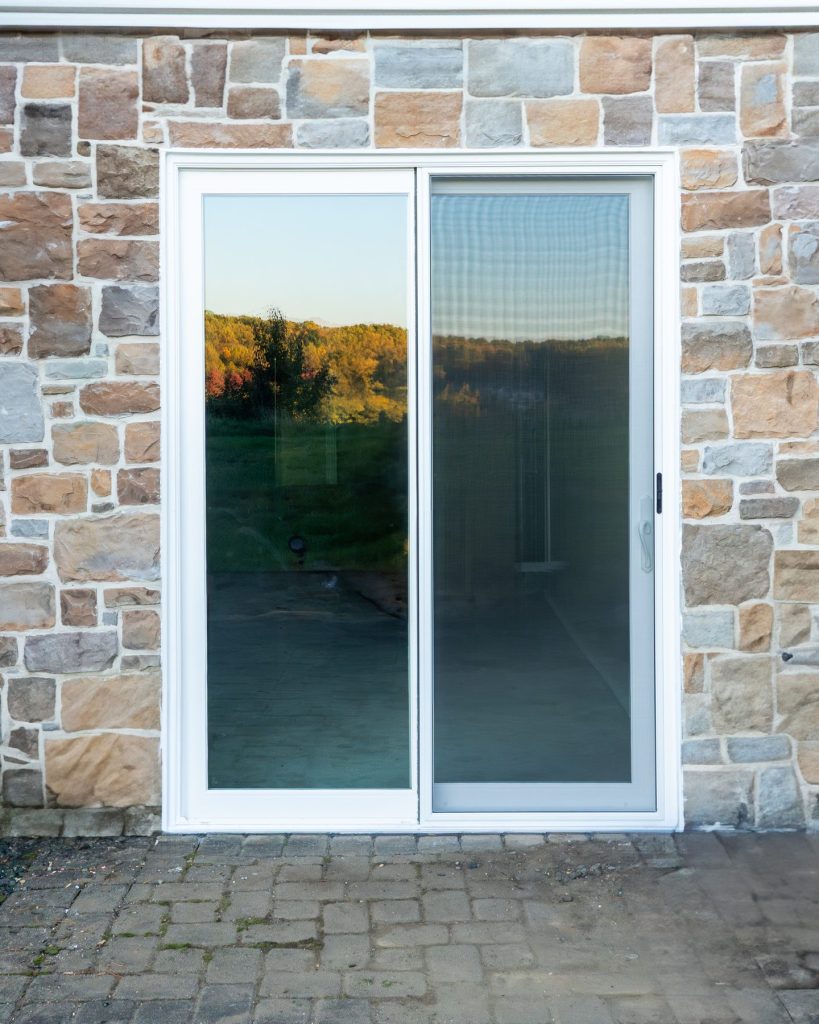 Vytex Signature Series white patio door on a stone home at sunset