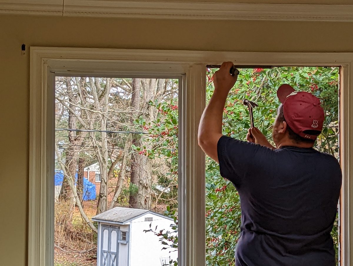 Installer removing an old window frame before fitting a new Vytex replacement window