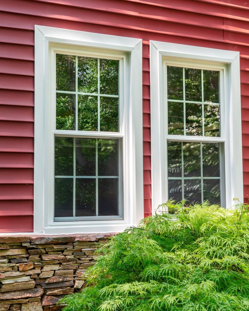 Vytex Potomac-HP double-hung windows with colonial grids on red clapboard siding